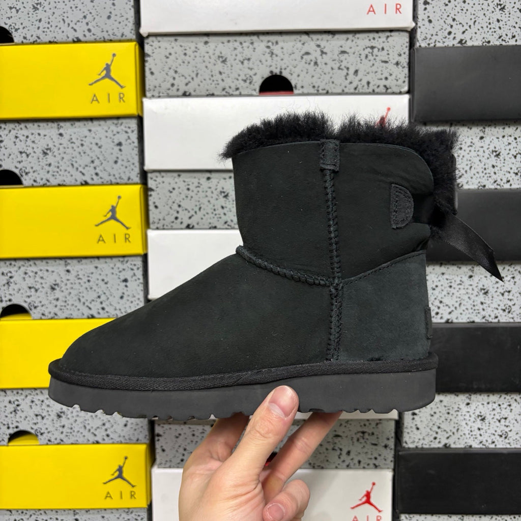 UGG Mini Bailey Bow Ankle Boot – Suede Boot with Tonal Black Shearling Lining, Black Satin Bow & All-Black Lug Sole in Black